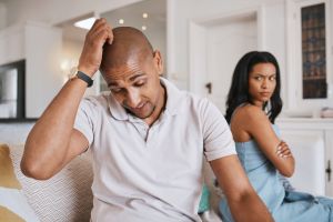 Couple, fight and stress on living room sofa for worry, mistake or angry with problem in house. Man, woman or depression for conflict, drama or frustrated on lounge couch for cheating, crisis or fail