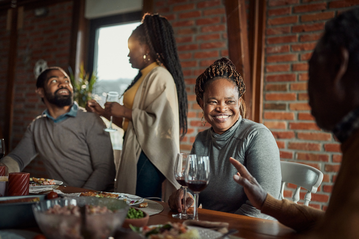 Happy black family enjoying in conversation during lunch at home.