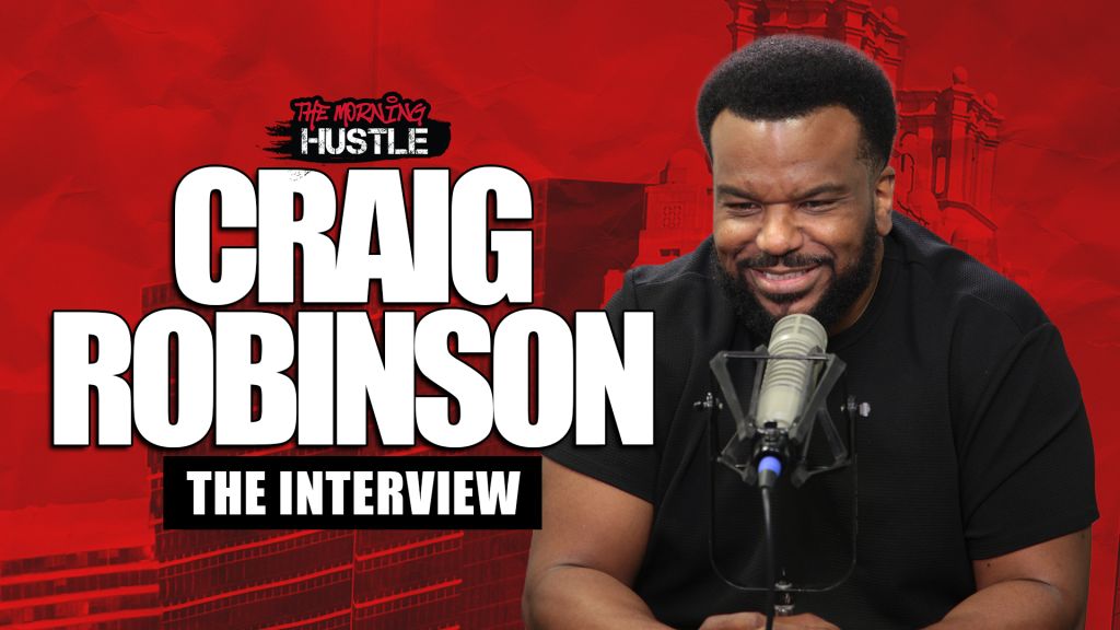 A smiling Black man with a microphone, wearing a black t-shirt, against a red background with the text "The Morning Hustle" and "Craig Robinson The Interview".