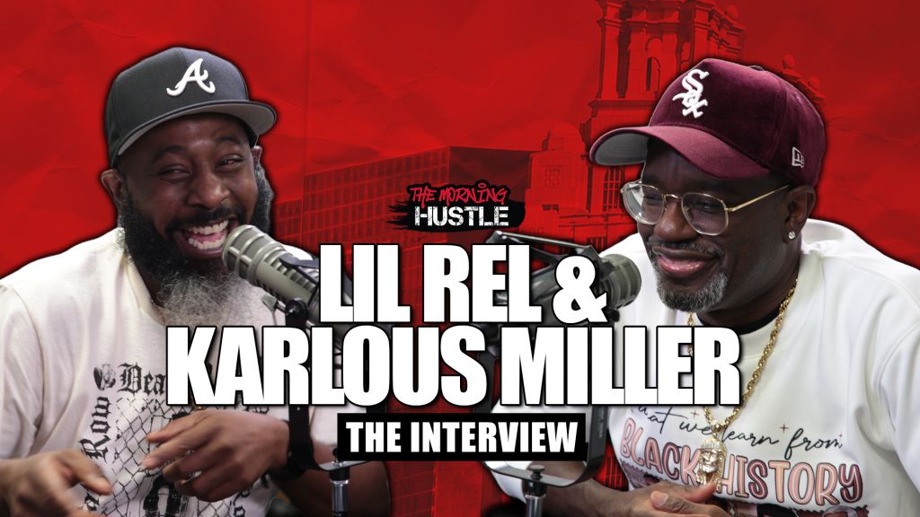 Two men wearing baseball caps with team logos, one with a beard, being interviewed on a red background with text "The Morning Hustle" and "Lil Rel & Karlous Miller: The Interview".